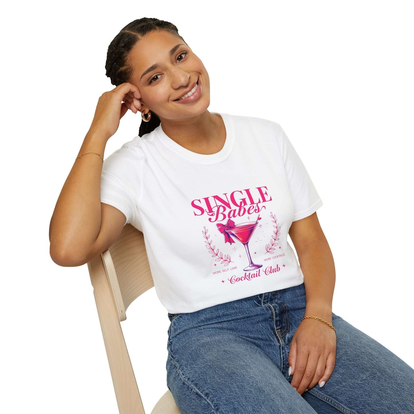 Smiling woman wearing a white t-shirt featuring the ‘Single Babes Cocktail Club’ design with a pink cocktail glass, floral accents, and elegant script text.