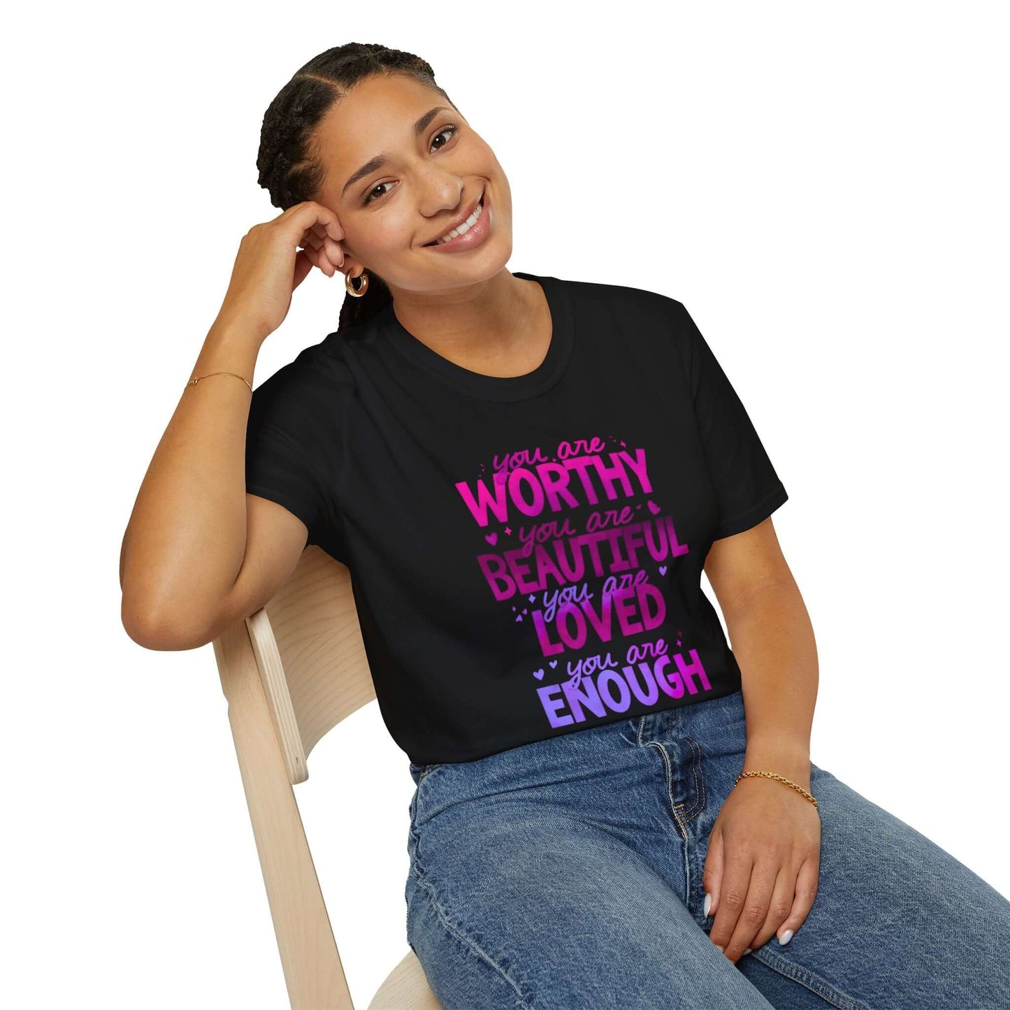 Smiling woman wearing a black unisex t-shirt featuring an inspirational design with the text ‘You are Worthy, You are Beautiful, You are Loved, You are Enough’ in pink and purple.