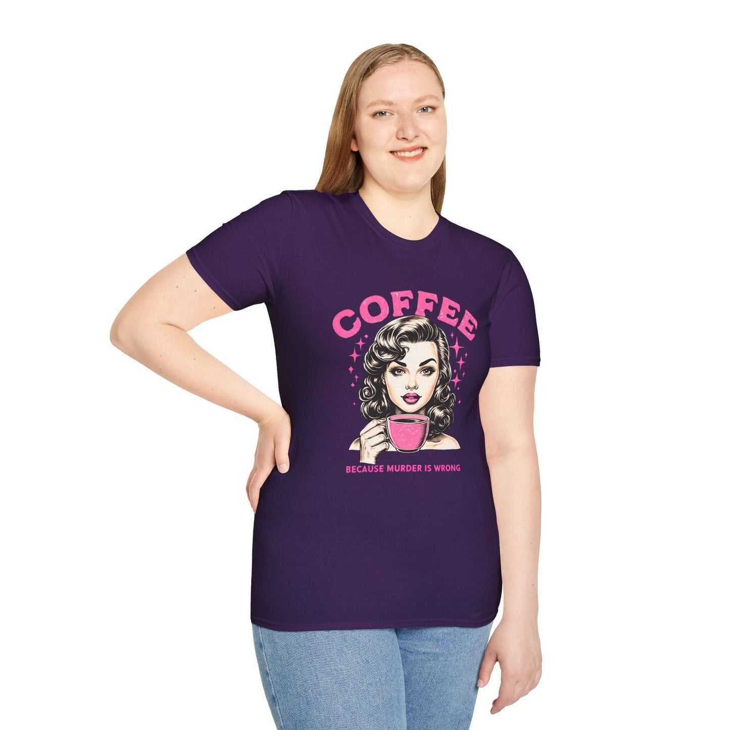 Smiling woman wearing a purple unisex t-shirt featuring a retro ‘Coffee - Because Murder Is Wrong’ design in pink, with a vintage-style woman holding a coffee cup illustration.