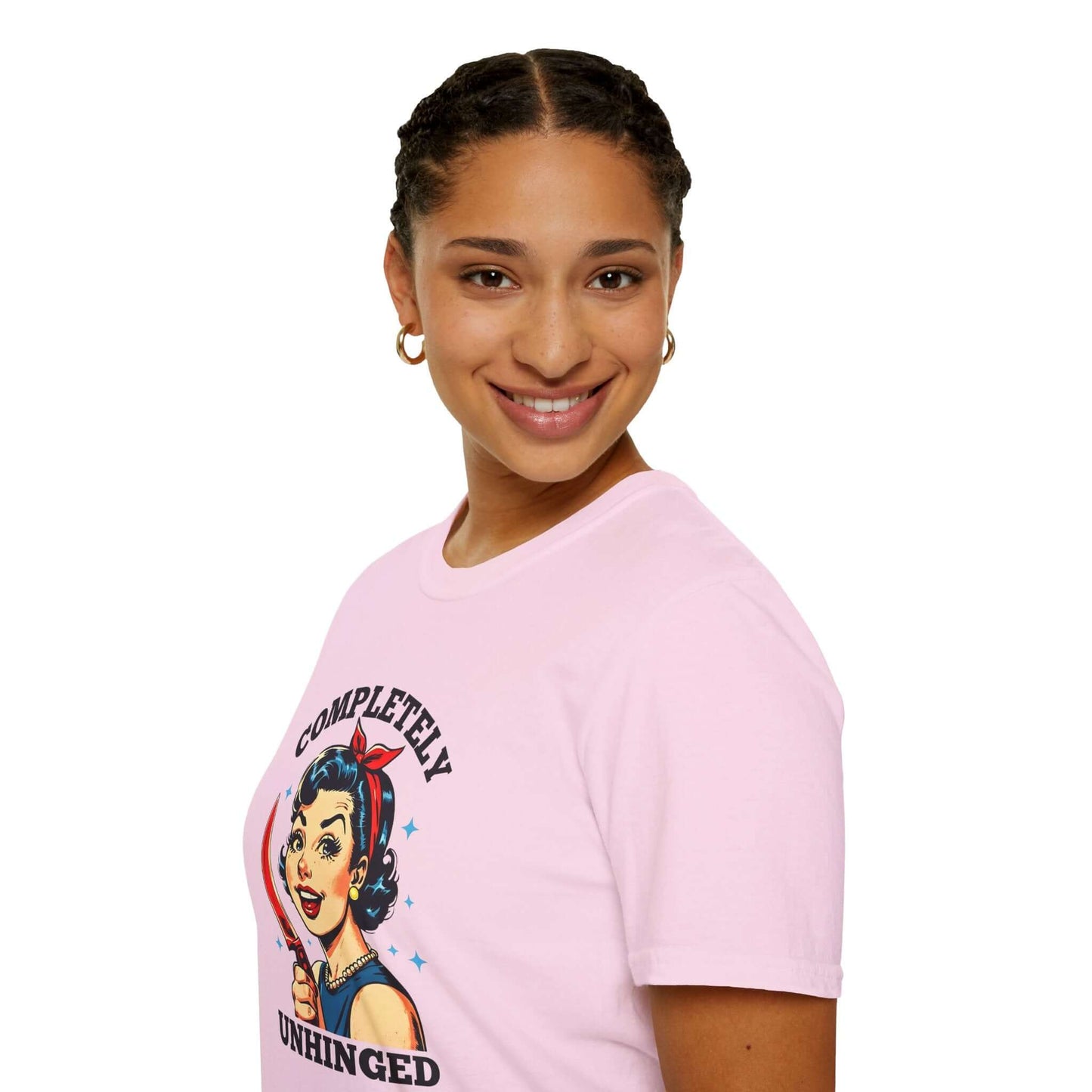 Smiling woman wearing a pink unisex t-shirt featuring a retro ‘Completely Unhinged’ design with a vintage-style woman holding a red knife and bold text.