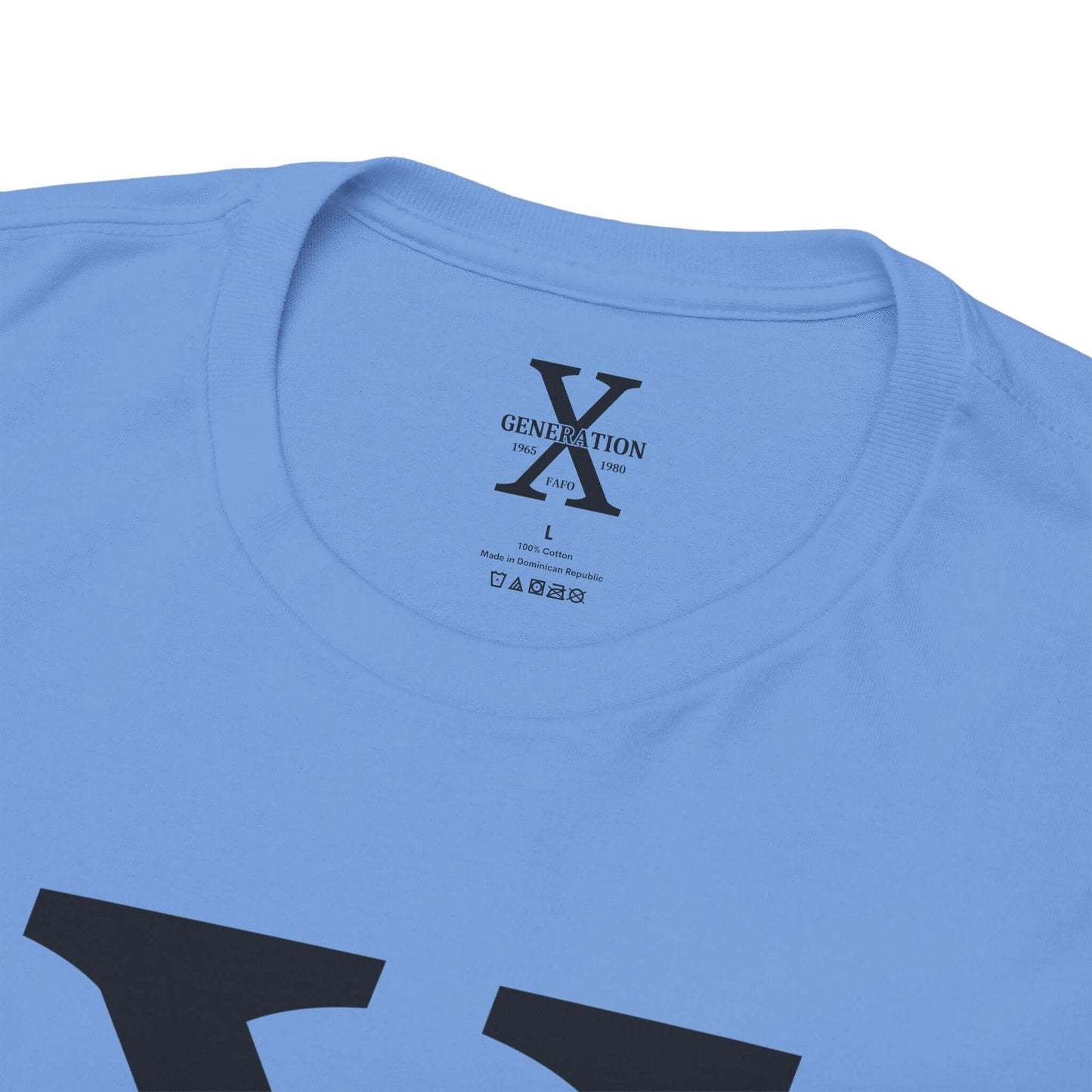 A blue t-shirt with a large white “X” on the front, representing Generation X. The inside collar features a printed label with the same “Generation X” design, size details, and care instructions.