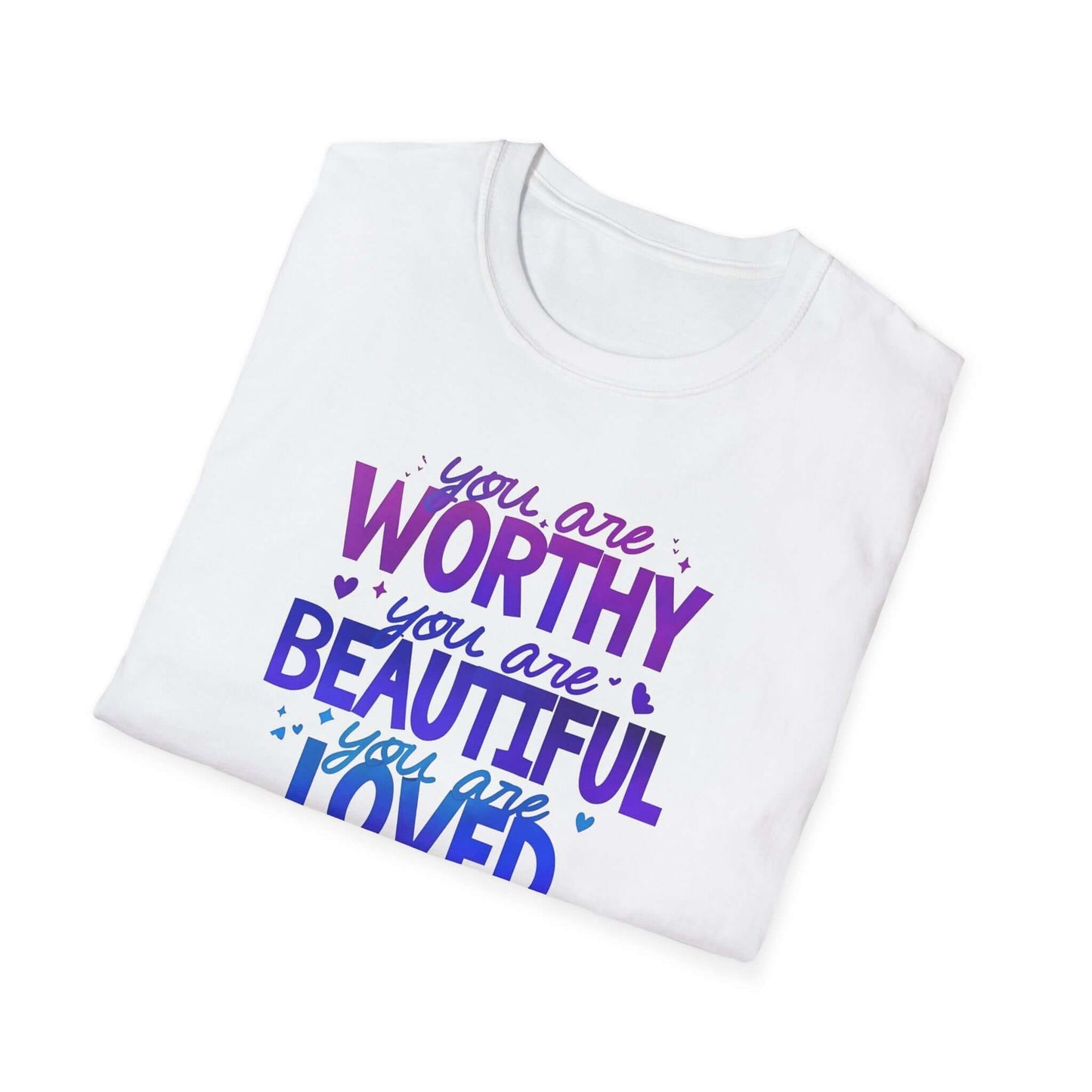 White folded t-shirt featuring the text ‘You are Worthy, You are Beautiful, You are Loved, You are Enough’ in purple and blue font.