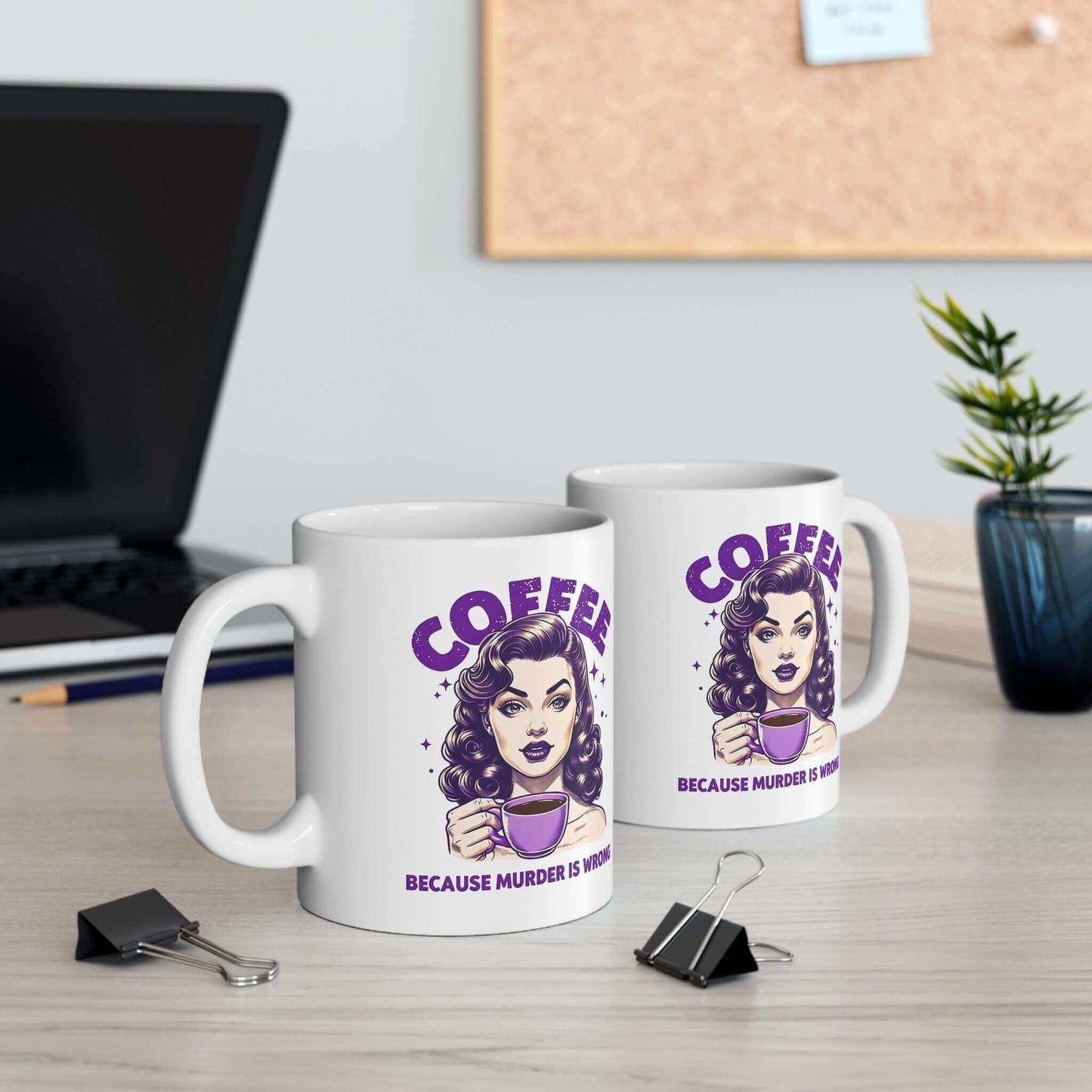 Two white ceramic mugs with a retro ‘Coffee - Because Murder Is Wrong’ design in purple, featuring a vintage-style woman holding a coffee cup, displayed on a desk.