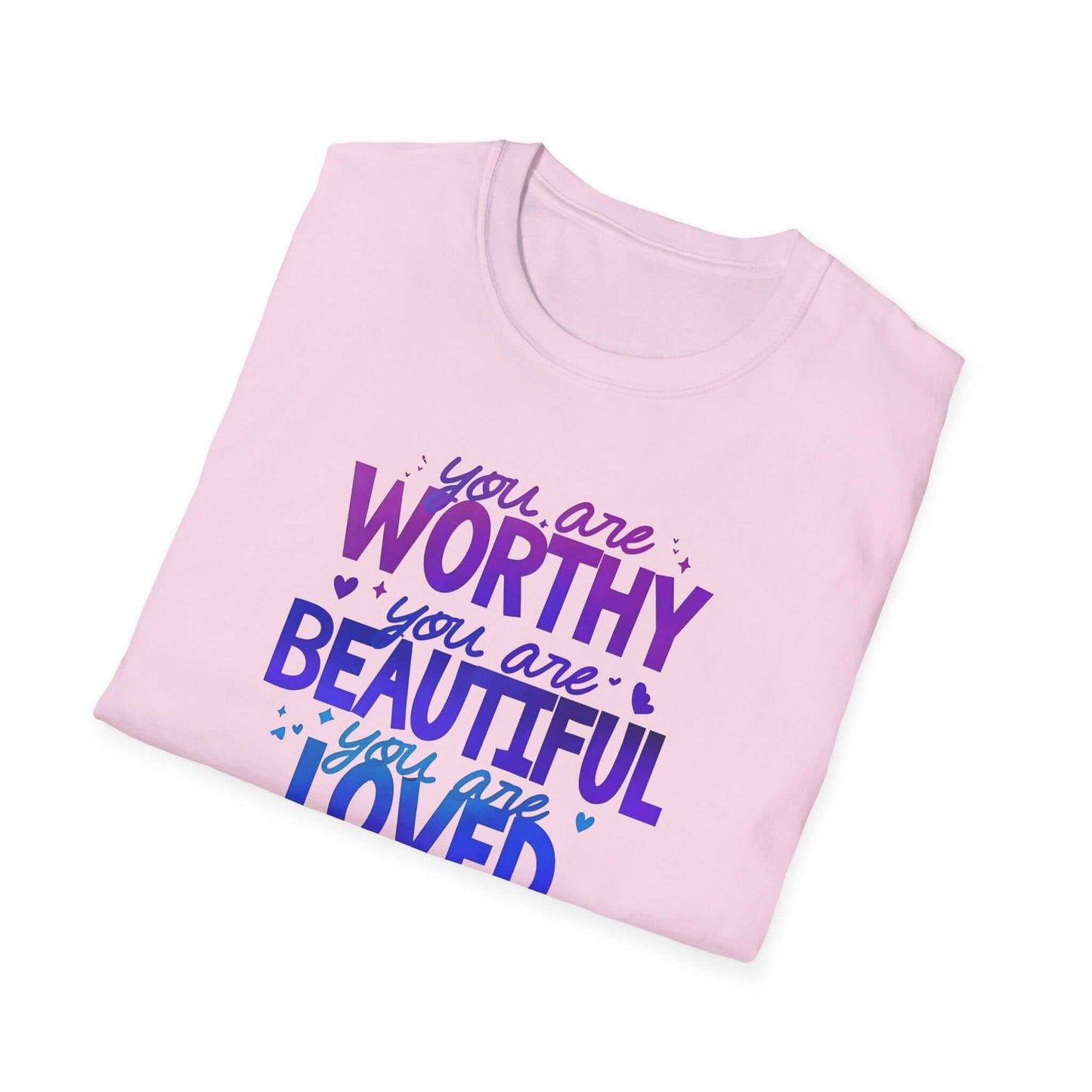 Pink folded t-shirt featuring the text ‘You are Worthy, You are Beautiful, You are Loved, You are Enough’ in purple and blue font