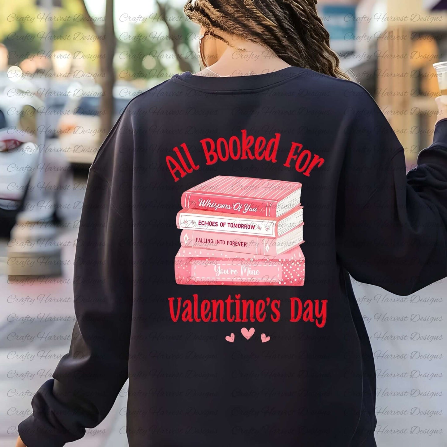 Back view of a person wearing a black sweatshirt featuring the ‘All Booked for Valentine’s Day’ design with a stack of pink books and romantic titles, accompanied by red text and heart accents.