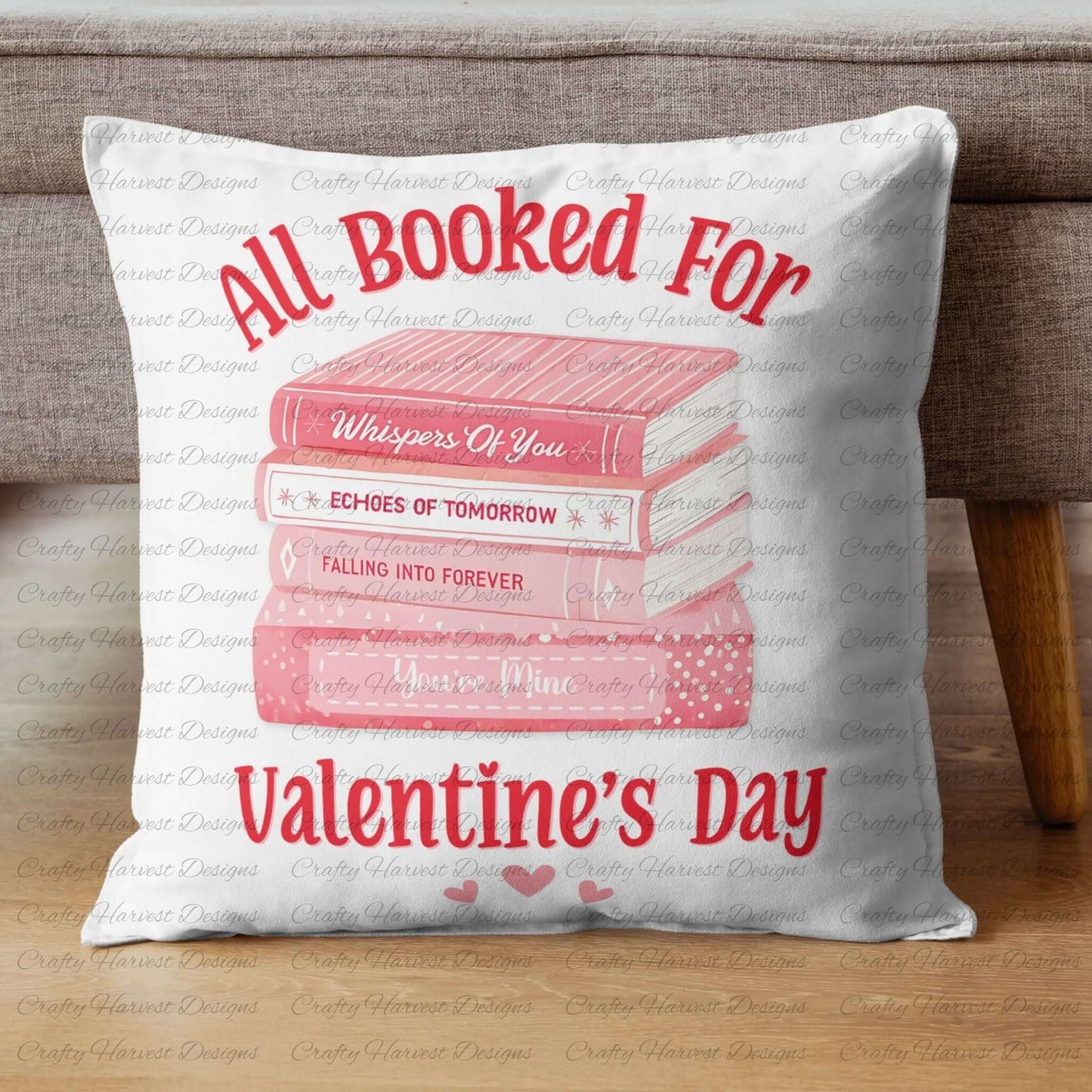 Square white pillow featuring the ‘All Booked for Valentine’s Day’ design with a stack of pink books and romantic titles, accompanied by red text and heart accents, placed on a neutral-colored couch.