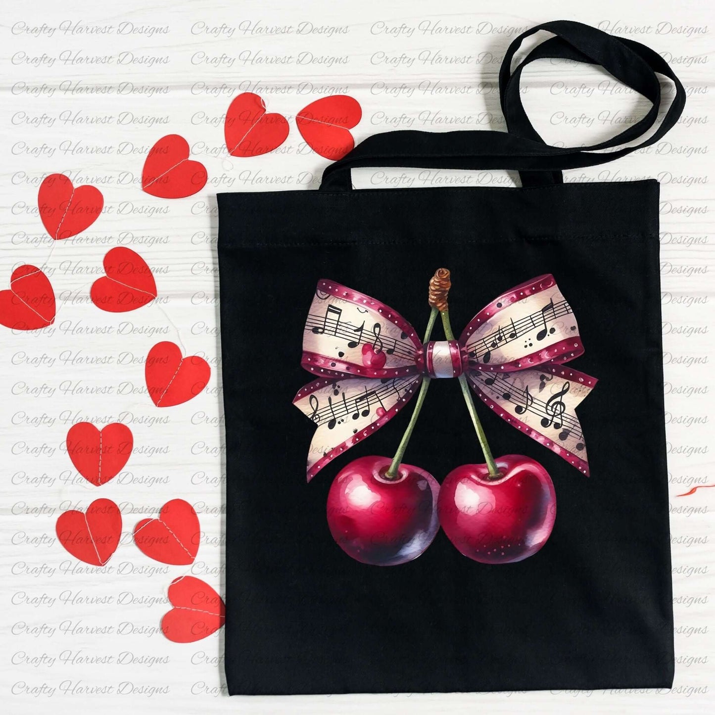 A black tote bag featuring a cherry design with a musical-themed bow. The bow has a pattern of sheet music, pink accents, and polka dots. The tote is displayed on a white surface with scattered red heart decorations.