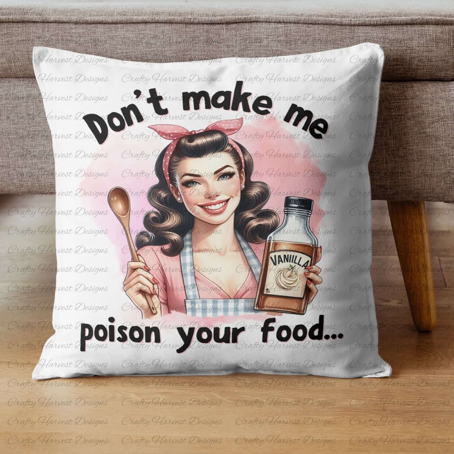 A decorative throw pillow featuring a vintage-style design of a smiling retro housewife holding a wooden spoon and a bottle labeled “Vanilla.” The text above and below the illustration reads, “Don’t make me poison your food…” The pillow is placed on a wooden surface with a fabric background.