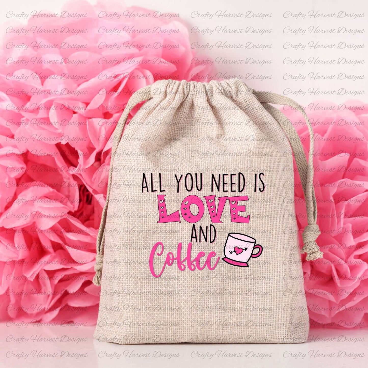 Natural linen drawstring bag featuring the All You Need is Love and Coffee design in pink and black, with a pink coffee cup graphic and heart detail, set against a backdrop of pink tissue paper flowers.