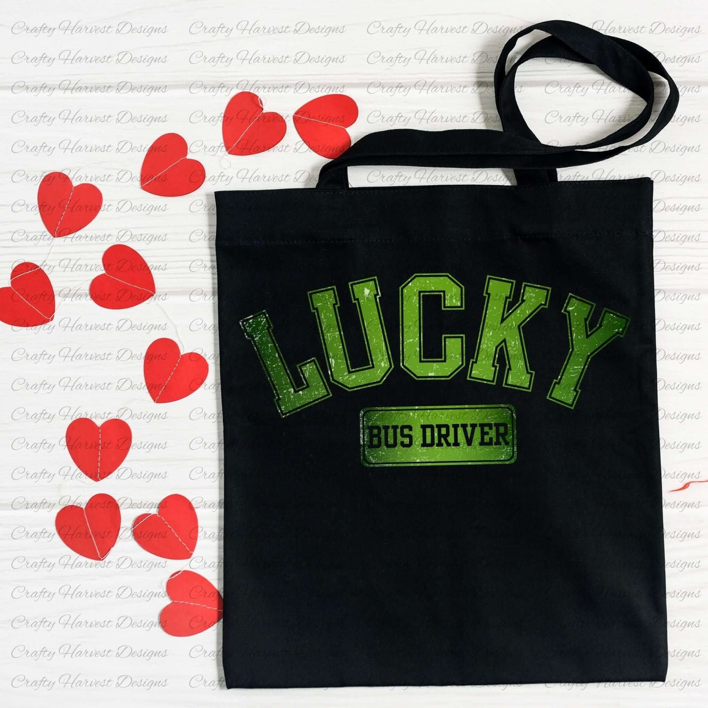 Black tote bag featuring the ‘Lucky Bus Driver’ St. Patrick’s Day design in bold green text. The bag is displayed on a white surface decorated with red heart-shaped cutouts.