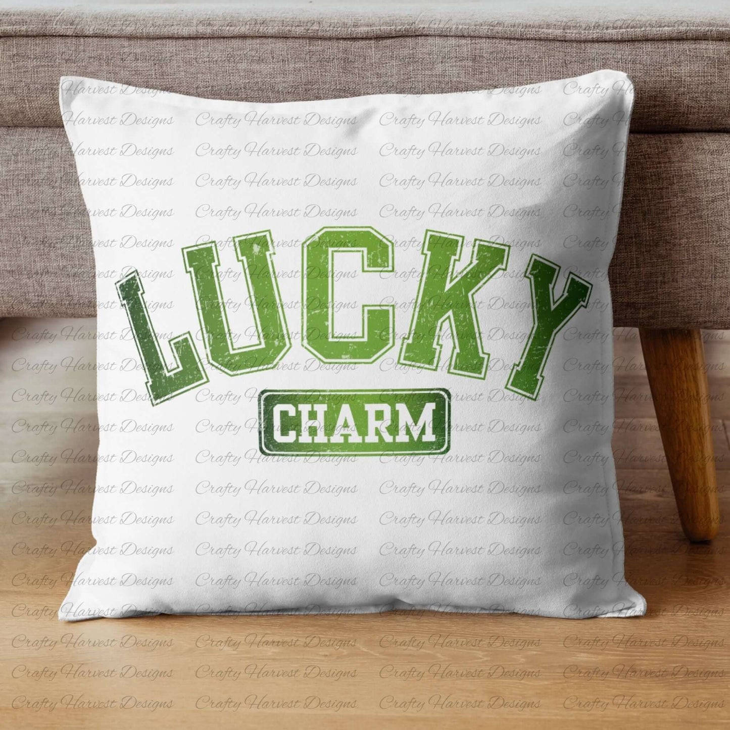 White throw pillow featuring the ‘Lucky Charm’ St. Patrick’s Day design in bold green text. The pillow is displayed on a wooden floor against a gray couch.