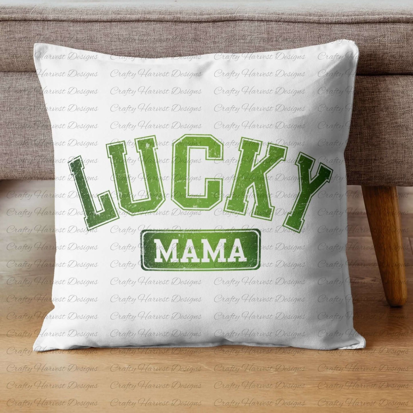 White throw pillow featuring the ‘Lucky Mama’ St. Patrick’s Day design in bold green text. The pillow is displayed on a wooden floor against a gray couch.