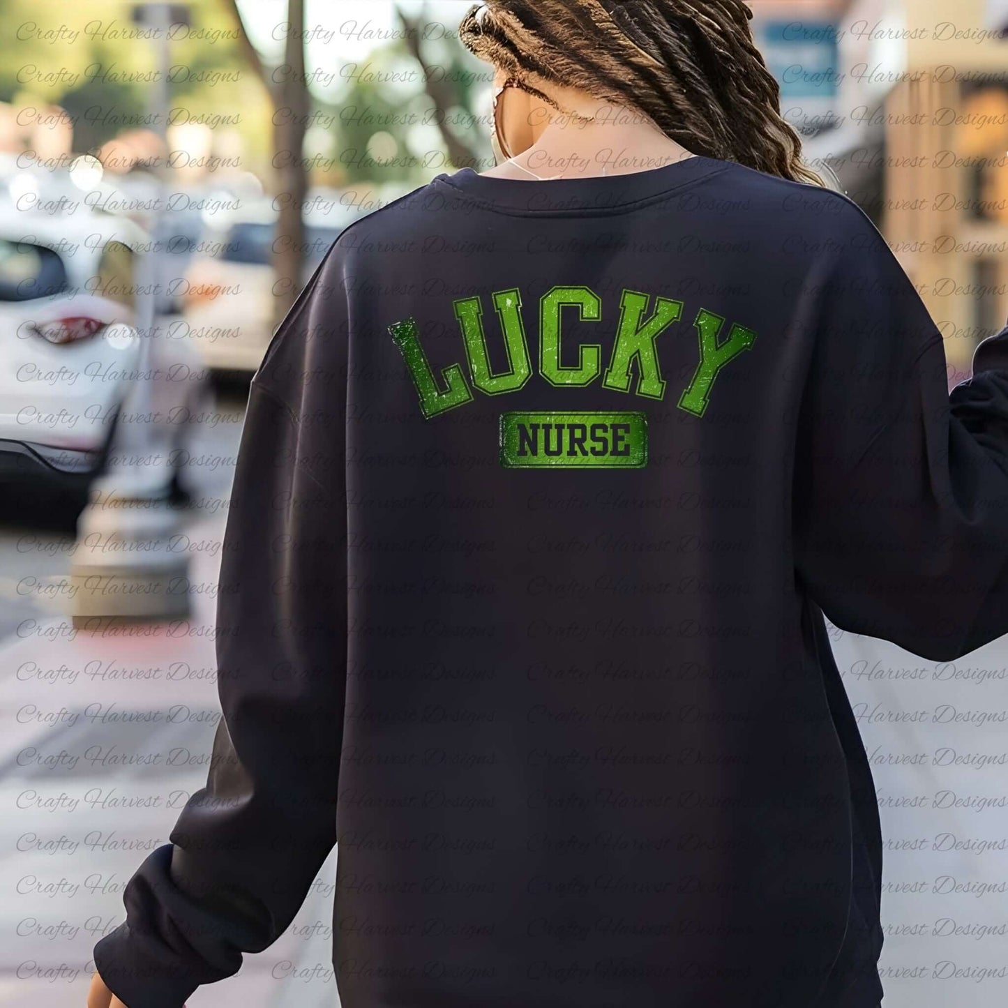 Rear view of a woman wearing a black sweatshirt with the ‘Lucky Nurse’ St. Patrick’s Day design in bold green text. The background features an outdoor street setting with blurred trees and parked cars.