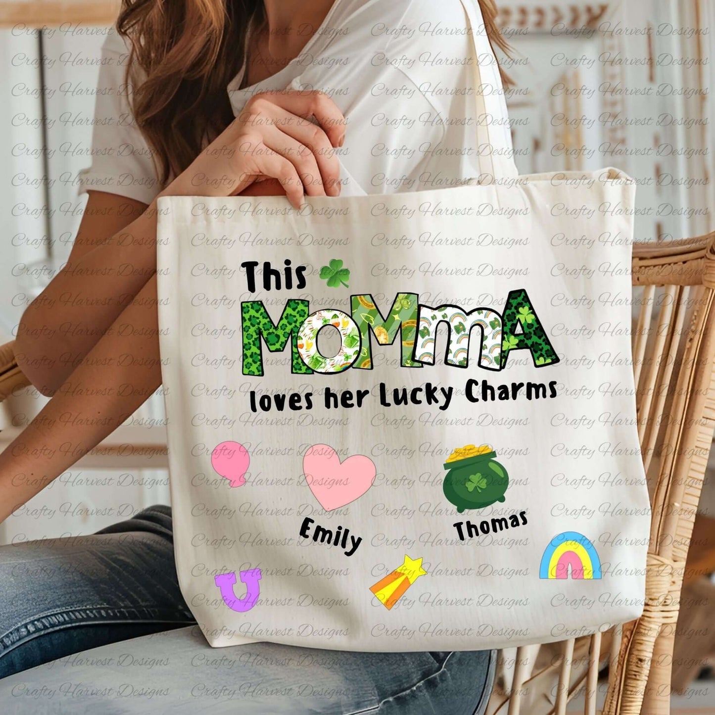 Tote bag with a “This MOMMA loves her Lucky Charms” design, featuring green-patterned letters and six colorful charm icons with names “Emily” and “Thomas” beneath them.