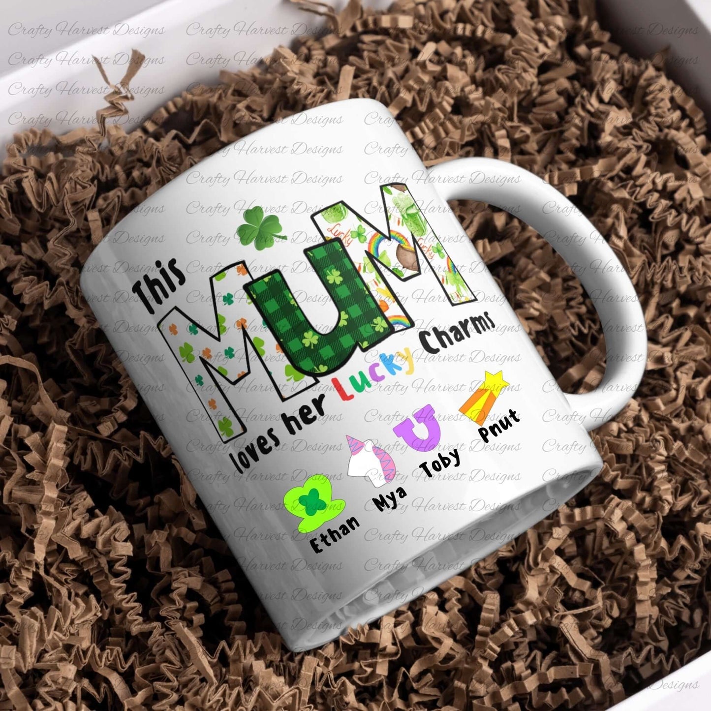 White ceramic mug with a “This MUM loves her Lucky Charms” design, featuring green-patterned letters and colorful charm icons with names below.