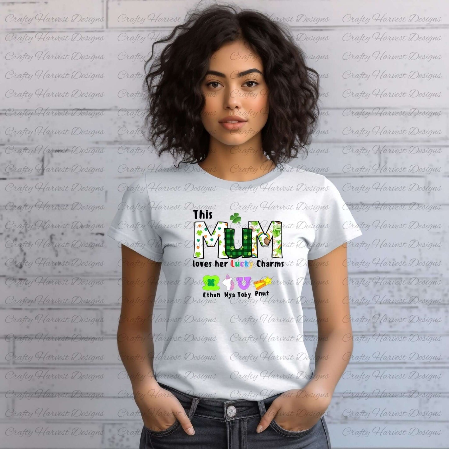 Woman wearing a white t-shirt with a “This MUM loves her Lucky Charms” design, featuring green-patterned letters and colorful charm icons with names below.