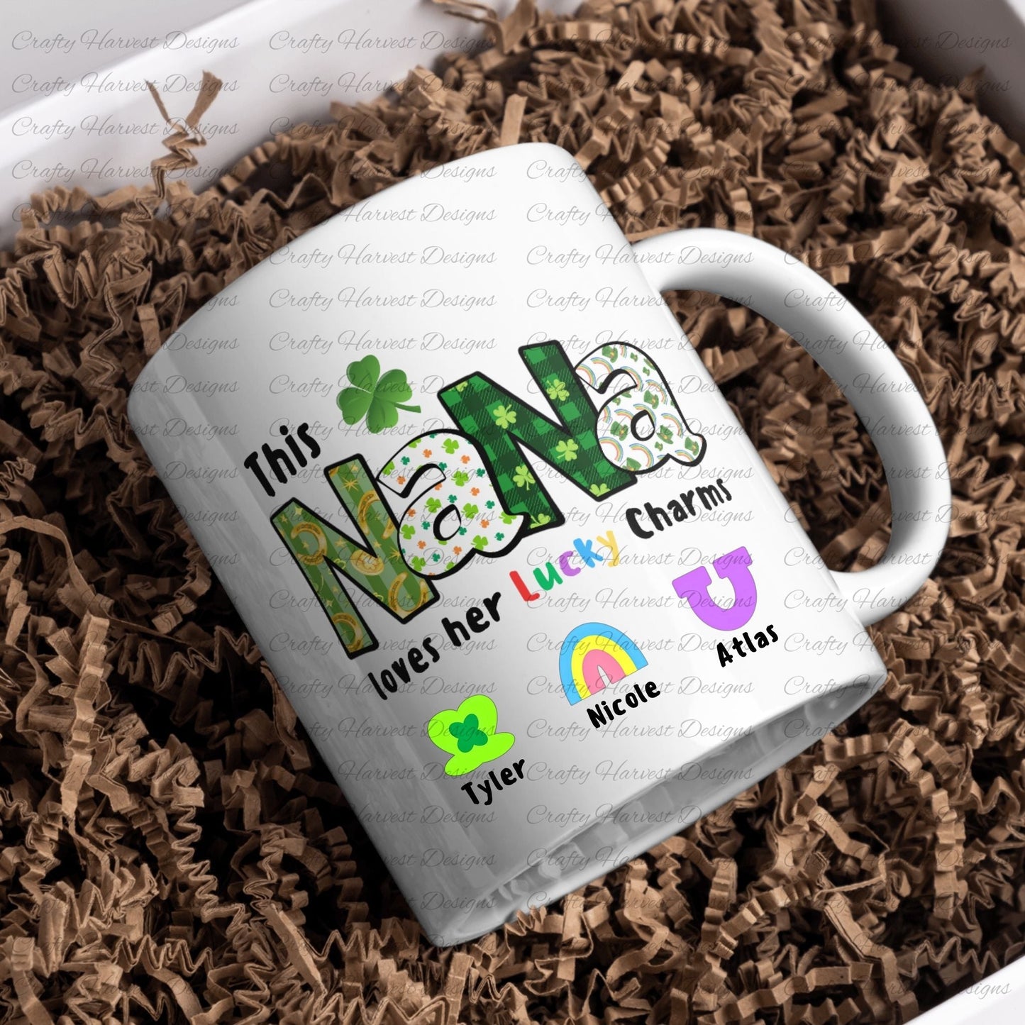 White ceramic mug with a “This NANA loves her Lucky Charms” design, featuring green-patterned letters and two colorful charm icons with the names “Emily” and “Thomas” below them.