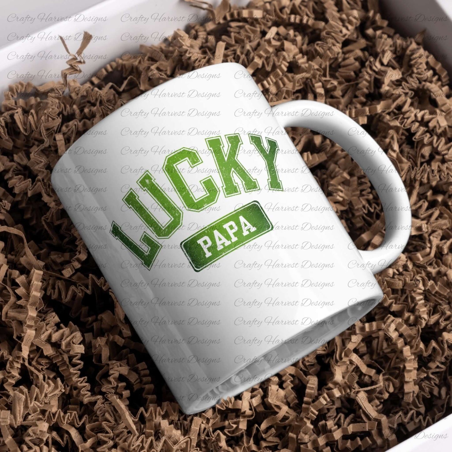 White ceramic mug featuring the design ‘Lucky Papa’ in bold green text with a St. Patrick’s Day theme. The mug is placed on a bed of brown crinkle paper for presentation.