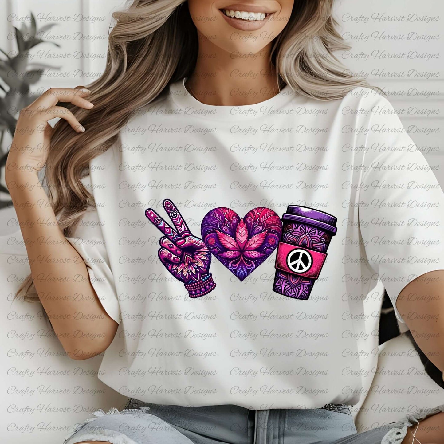 White t-shirt featuring a peace-themed design in vibrant purple and pink tones. Includes a peace sign hand, a heart with intricate floral patterns, and a coffee cup with a peace symbol, worn by a model with wavy blonde hair.