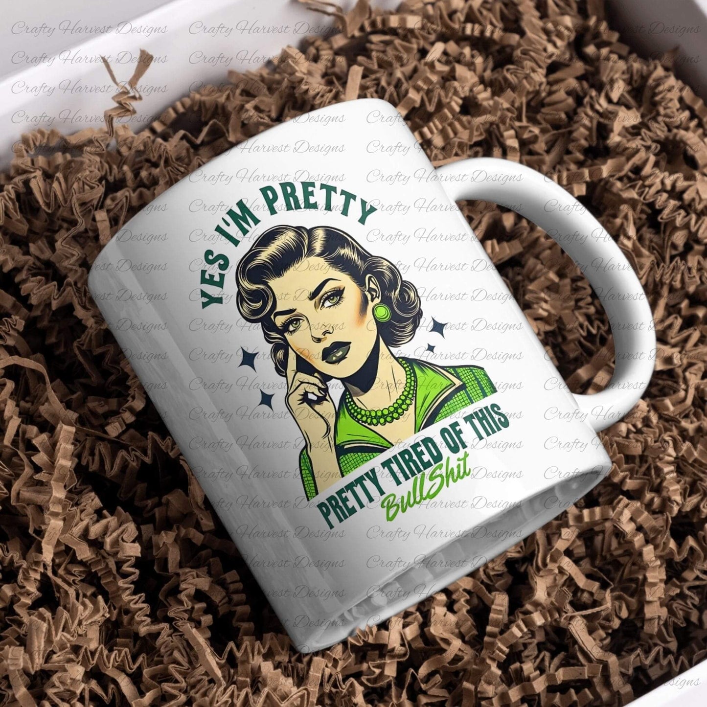 White ceramic mug featuring a retro-inspired digital design of a vintage-style woman with the humorous text ‘Yes I’m Pretty - Pretty Tired of This Bullsh*t’ in green and black colors. The mug is nestled in brown shredded paper, showcasing its appeal as a stylish and witty drinkware item or gift.