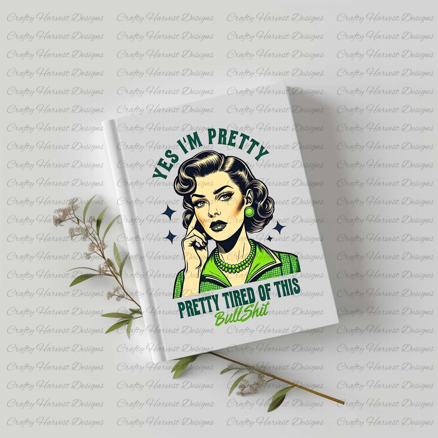 White hardcover notebook featuring a retro-inspired digital design of a vintage-style woman with the humorous text ‘Yes I’m Pretty - Pretty Tired of This Bullsh*t’ in green and black colors. The notebook is displayed on a light surface with sprigs of greenery, highlighting its use as a stylish and functional stationery item.