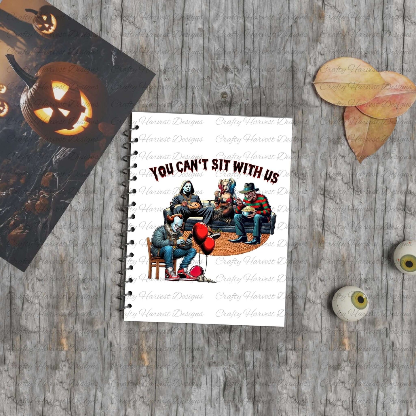 Mockup of the ‘You Can’t Sit With Us’ horror design featuring iconic characters lounging together on a notebook.