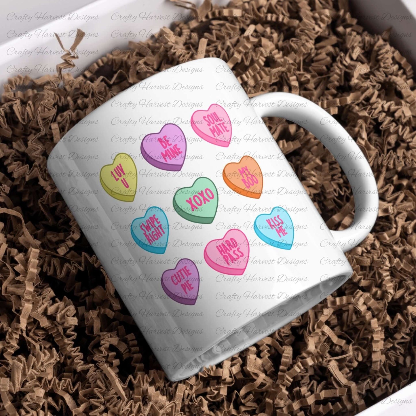 Mockup of a white mug featuring the traditional Valentine’s conversation heart design. The mug showcases colorful hearts with sweet phrases like “Luv U,” “Be Mine,” “Soul Mate,” “Swipe Right,” “XOXO,” “My Boo,” “Cutie Pie,” “Hard Pass,” and “Kiss Me.” The mug is placed on a bed of brown crinkle paper, making it gift-ready and perfect for Valentine’s Day projects.