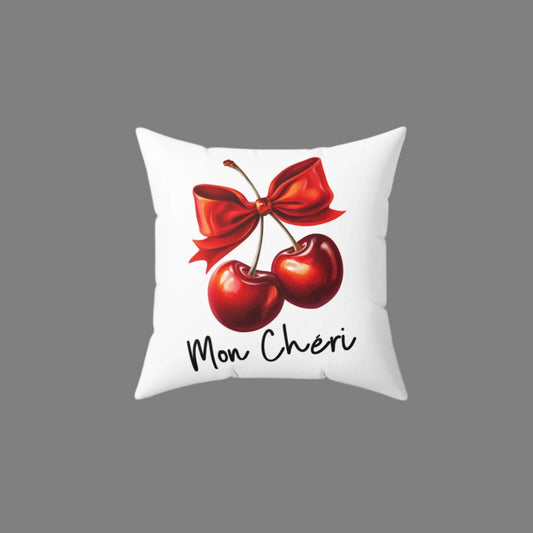 White throw pillow featuring a vibrant ‘Mon Chéri’ design with two red cherries tied with a bow and elegant text.