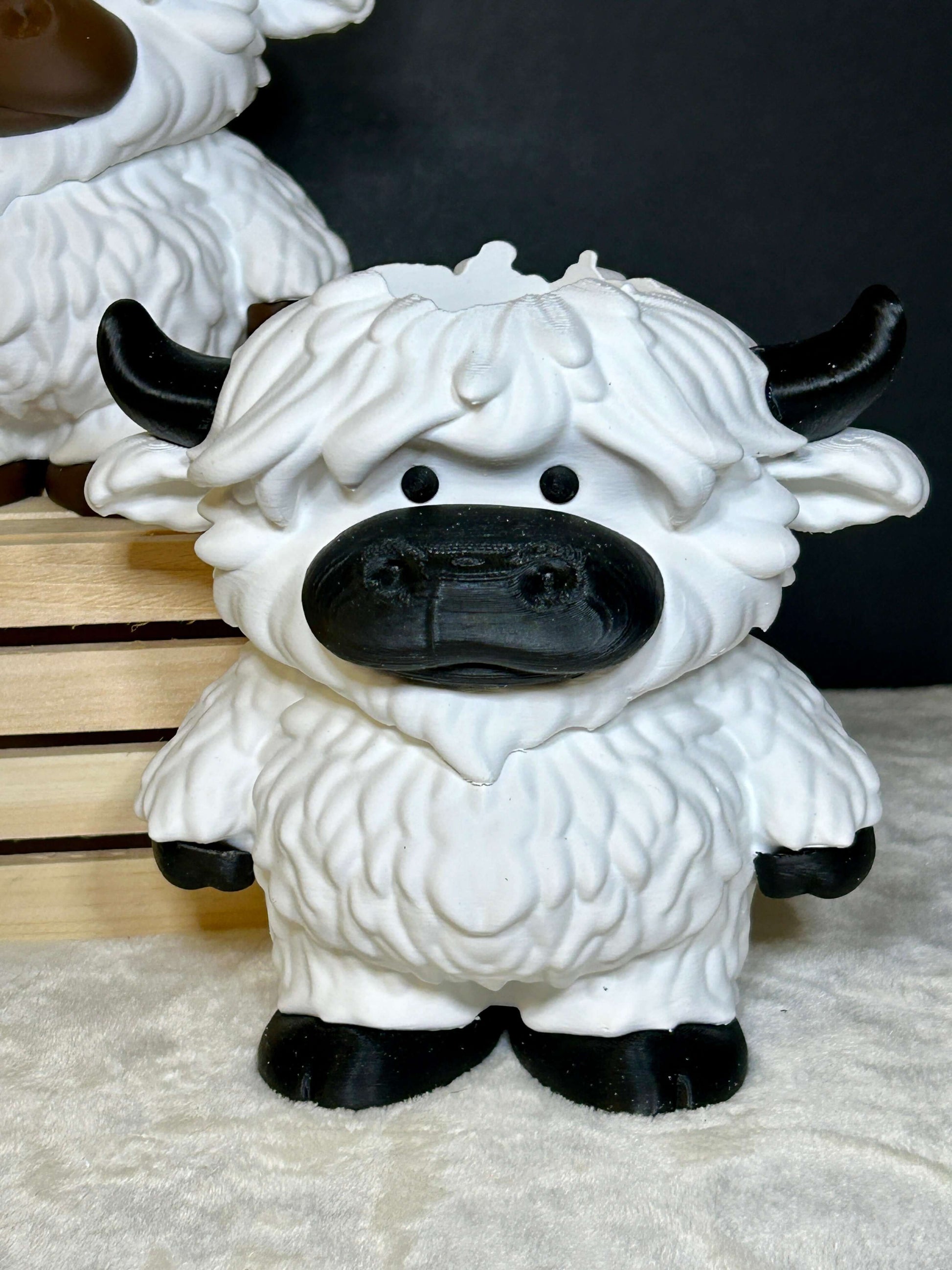 White and black cow soap holder with black hooves on a light cream colored surface