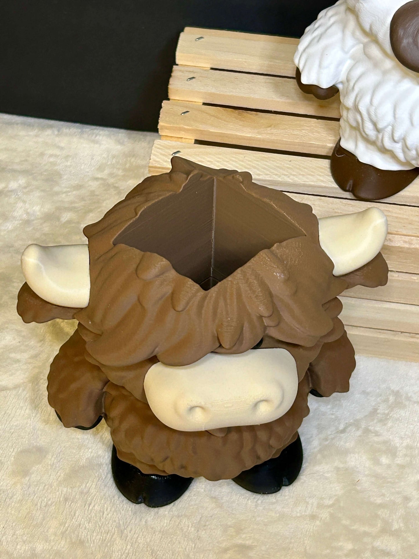 Brown cow soap holder with black hooves on a light cream colored surface