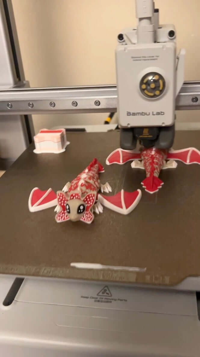 video of 3D printed demogorgon models on a 3D printer bed with Bambu Lab printer in the background.