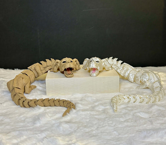 Two snake-like creatures, one beige and one white, on a white platform with a dark background.