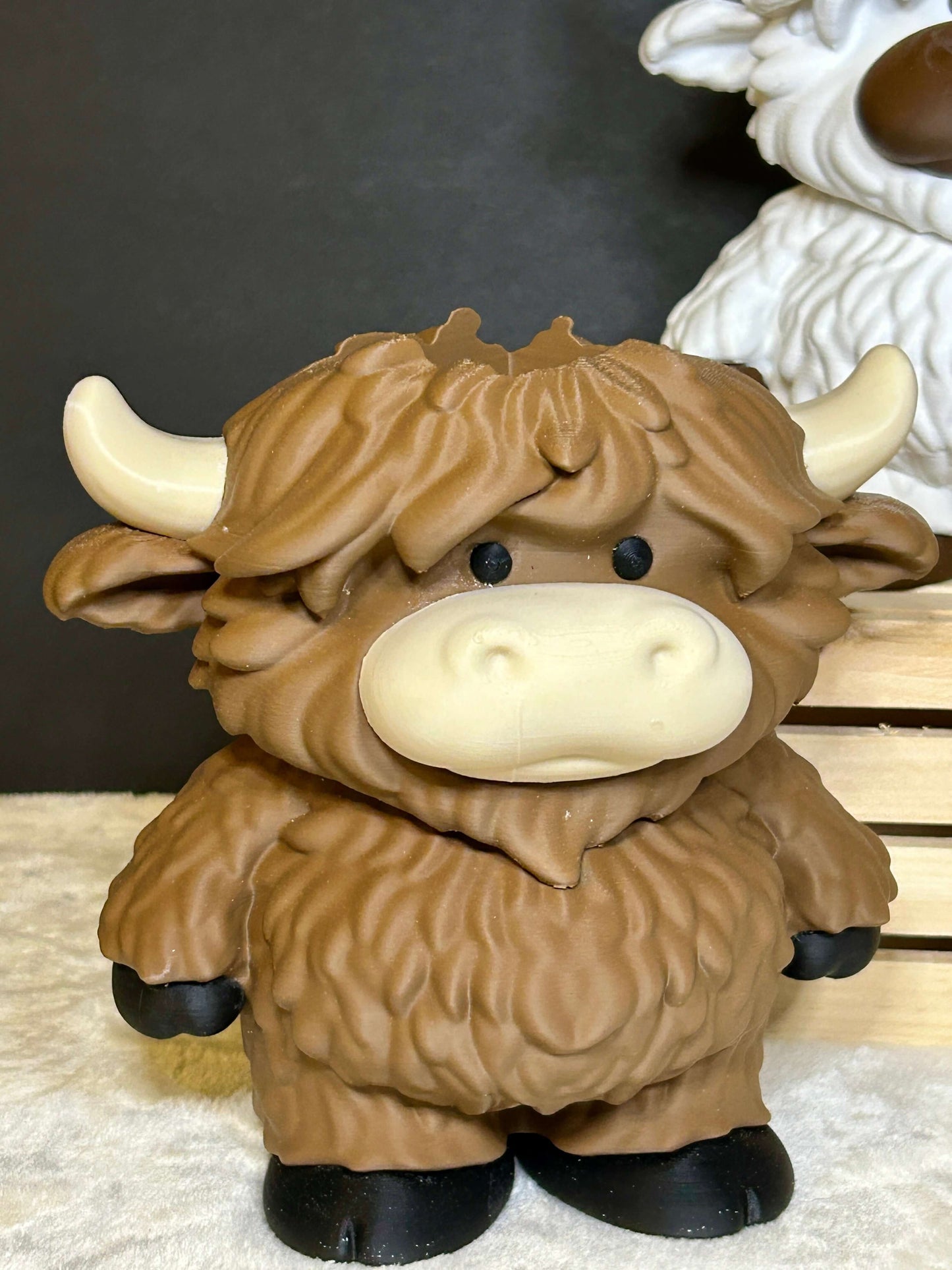 Brown cow soap holder with black hooves on a light cream colored surface