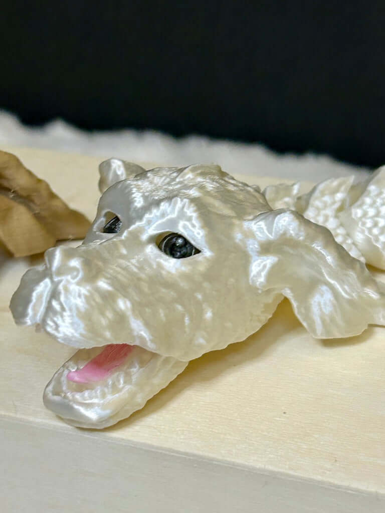 White 3d printed dragon head on a wooden base with a dark background