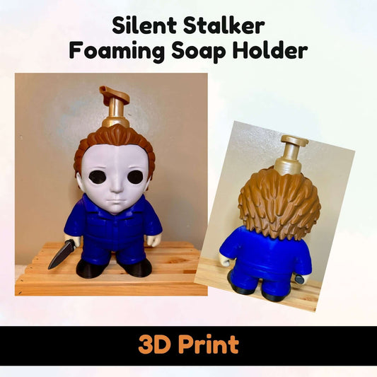 A 3D-printed foam soap holder shaped like a stylized character with a white face, brown hair, and a blue jumpsuit, shown from front and back views on a light background with text reading 'Silent Stalker Foaming Soap Holder' and '3D Print'.
