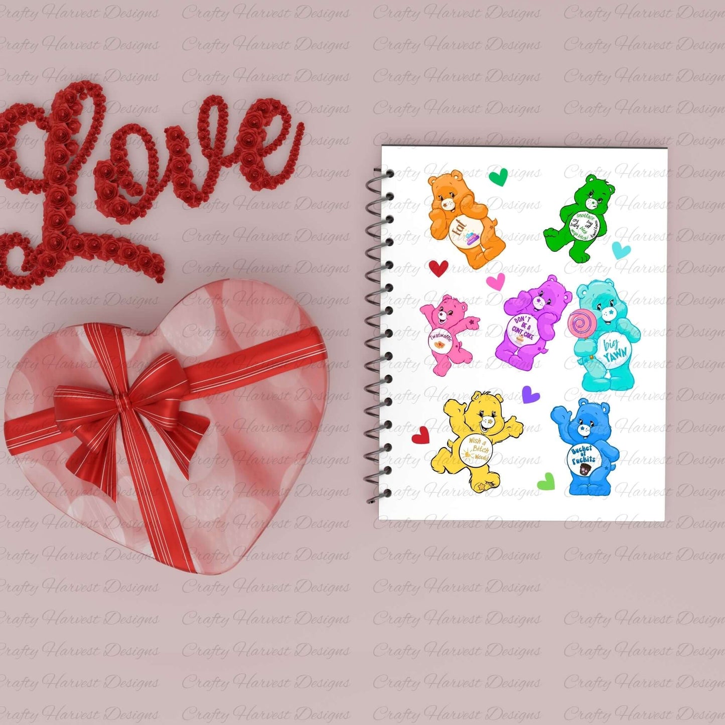 Spiral-bound notebook mockup featuring colorful Swear Bears with phrases like “Eat,” “Why Tho?,” “Don’t Be a Cunt Cake,” and “Wish a Bitch Would.” The scene includes a heart-shaped gift box with a red ribbon and a floral “Love” sign.