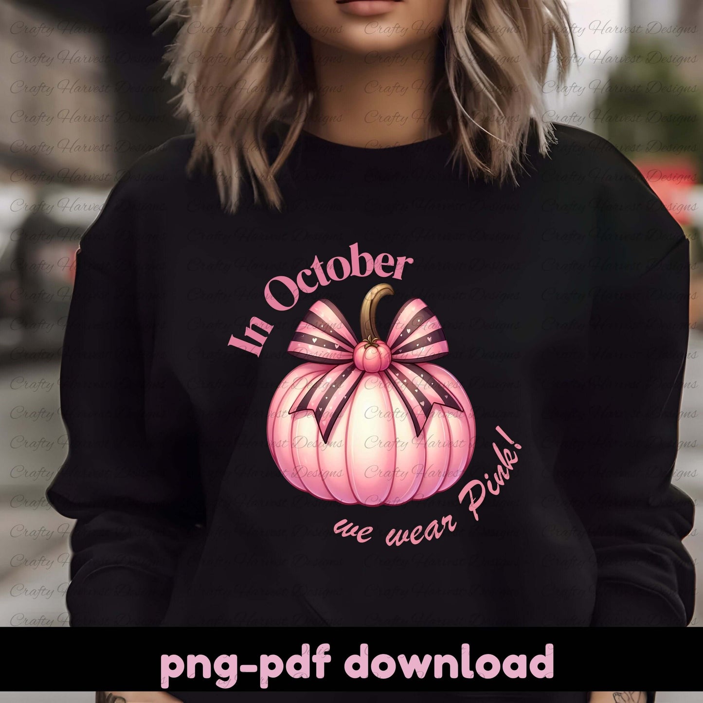 Person wearing a black sweatshirt with a pink pumpkin design and text.