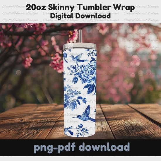 This rotating mockup showcases the blue and white floral tumbler wrap, featuring intricate peonies and hummingbirds, on a 20oz skinny tumbler. The tumbler is displayed outdoors on a wooden surface with pink blossoms in the background, emphasizing its elegant design.